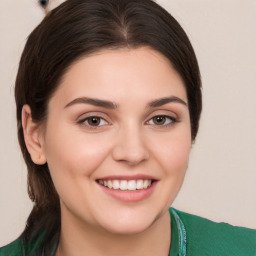 a young woman smiling in a green shirt.