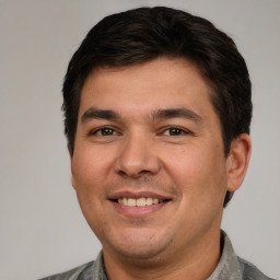 a portrait of a man wearing a gray shirt.